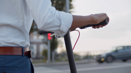 Close up of african man with scooter standing waiting for green light at crosswalk