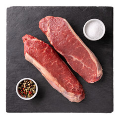 Two pieces of striploin beef steak with salt and pepper on black slate board isolated on white. Raw fresh meat.