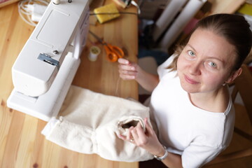 Beautiful woman cutting dress patterns in home with her little cute girl