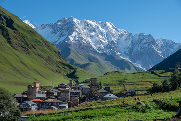 Ancient authentic village Ushguli, the Svaneti UNESCO World Heritage Site and one of the highest settlements in Europe. Bezengi wall and mount Shkhara, the highest mount in Georgia, on the background.