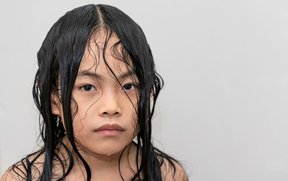 Portrait Asian Child Girl After Taking Shower, Hair And Body Still Wet, Unpredictable Or Cold Emotion, Eyes Looking At Camera, Not Smile.