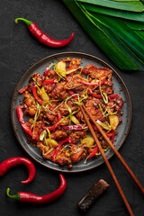 Kkanpunggi or Korean Spicy Garlic Fried Chicken on black plate on dark slate table top. Kan Pung Gi is korean and chinese cuisine dish. Typical asian food and meal.