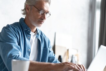 Middle-aged man working from home-office on laptop