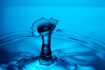 Water drop falling down. Abstract blue background