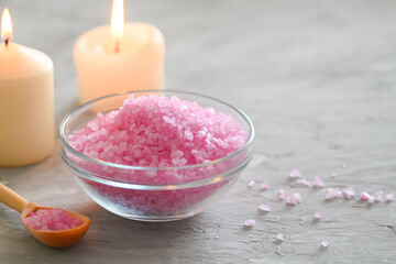 Obraz na płótnie Canvas Pink close-up of bath salt in the glass bowl with aroma candles with copy space