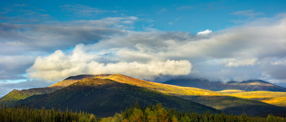 Panoramic autumn landscape in the Brooks Range, Alaska with mountains partly shrouded in clouds 