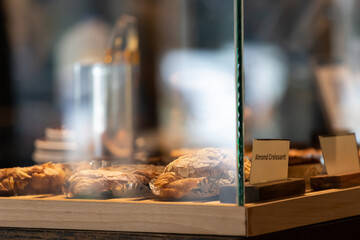 almond croissant in glass display in bakery shop.