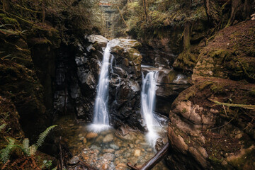 Beautiful view of water cascading in a canyon surrounded by green nature. Cypress Water Fall, West Vancouver, British Columbia, Canada.