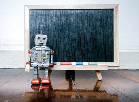 robot and a  blacboard on a wooden floor