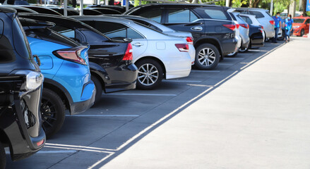 Closeup of rear, back side of blue car with  other cars parking in parking lot in bright sunny day. 