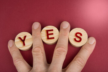 Yes sign on a wooden circles on a red