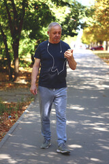 Naklejka na ściany i meble Soft focus. Toning. Senior man on the street is engaged in fitness. Healthy lifestyle in old age concept. Recovering health after illness.