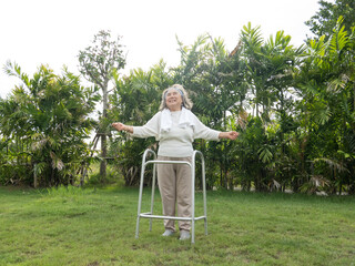 Smile happy elderly Asian woman use walker with strong health while walking in the garden