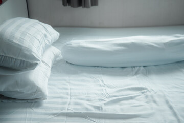 Fototapeta na wymiar White pillow and white bolster on white bed in home