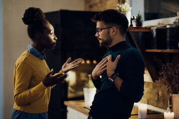 Young couple with relationship difficulties arguing at home.
