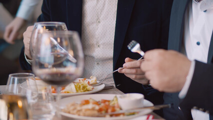 Close up of confident business partners having lunch together in modern cafe