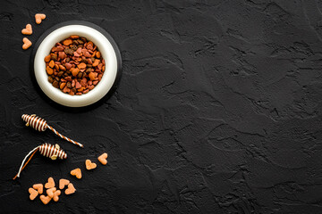 Dry cat food in bowl with toy, top view