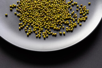 Mung beans close-up on a black dish. Healthy food, cereals.