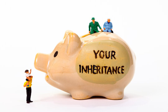 Conceptual  image of miniature figure pensioners sat on a piggy bank with the words Your Inheritance