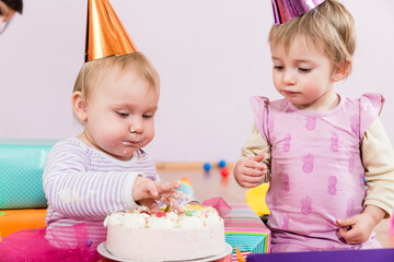 Two toddlers with birthday cake