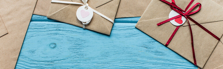 top view of wooden blue background with envelopes and hearts, panoramic shot