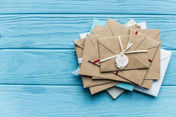 Top view of wooden blue background with envelopes and heart