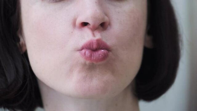 Close-Up Brunette Woman Smiles and Sends Kiss. On Face Smile with Teeth, Kiss