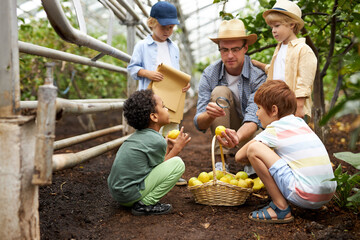 the guide man conducts an introductory lecture for children in the garden or greenhouse, kids...