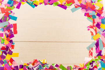 Fototapeta na wymiar top view of colorful bright confetti frame on wooden background