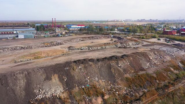 aerial video of a city garbage dump in the background of the city,