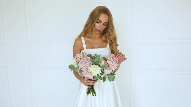 female hands a gift bouquet of flowers Bride in white dress Woman blonde

