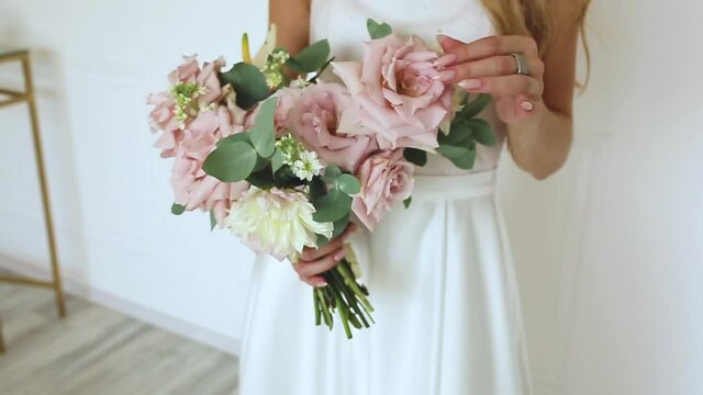 female hands a gift bouquet of flowers Bride in white dress Woman blonde
