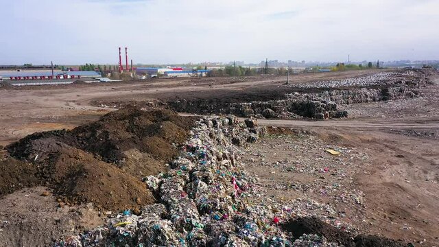 aerial video of a city garbage dump in the background of the city,