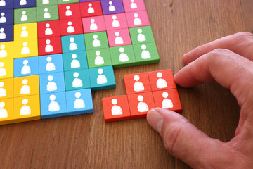 image of tangram puzzle blocks with people icons over wooden table ,human resources and management...