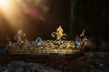 mysterious and magical photo of gold king crown in the England woods over stone. Medieval period...