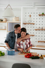 Young couple in kitchen. Husband and wife making salad