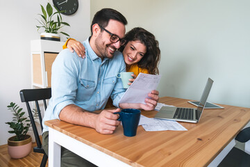 Smiling couple manage finances at home stock photo