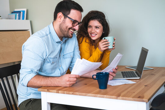 Smiling couple manage finances at home stock photo
