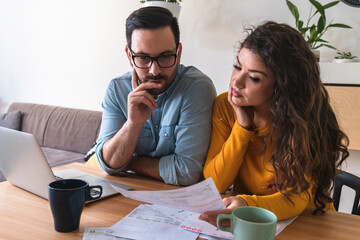 Worried couple calculating and paying bills online stock photo