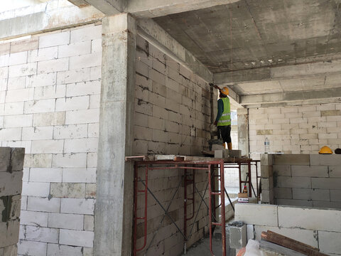 SEREMBAN, MALAYSIA -MARCH 16, 2020: Construction workers laying autoclaved aerated concrete block at the construction site. The use of this material can save time and facilitate construction work.