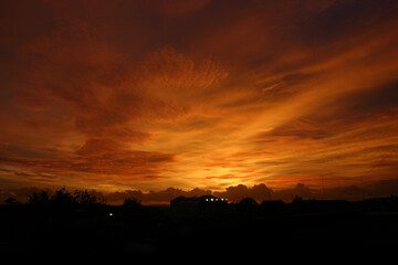 Dusk with yellow clouds. Silhouette of a building roof