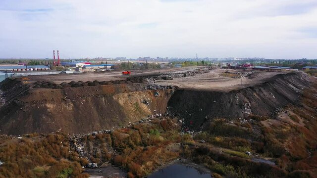 aerial video of a city garbage dump in the background of the city,