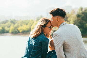 A lovely photo of a young family near a lake sitting together