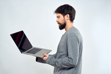 A man in a gray sweater with a laptop hands lifestyle technology communication internet work