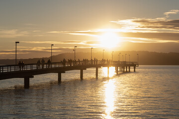 Fototapeta na wymiar Fishermen on Pier During Beautiful Sunset