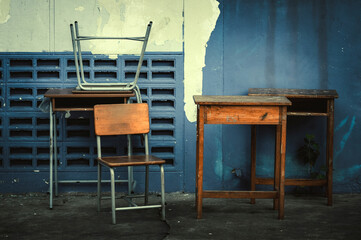 Old school desks, old chairs set outside the classroom.
