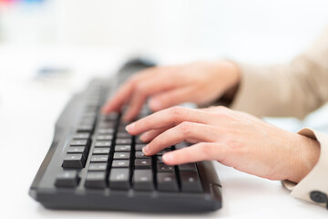 Woman typing on a computer keyboard