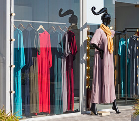 Female mannequin in floor skimming dress at shop window background with one size clothing