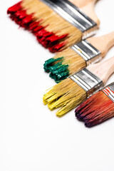 Fototapeta premium close up view of dirty paintbrushes on white background