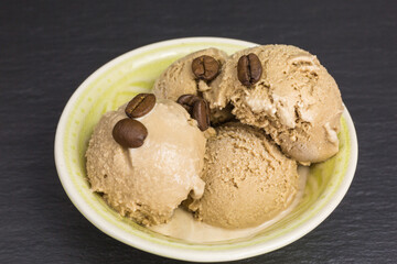 fresh coffee ice cream scoops in a bowl with coffee beans